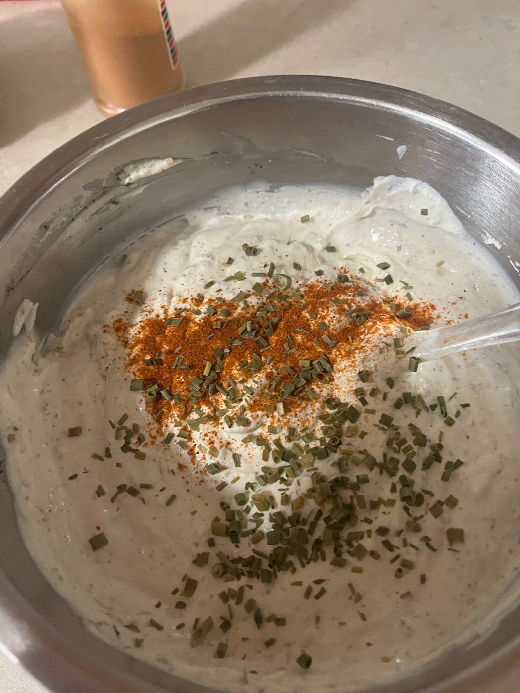 Sour cream topped with dill, paprika and spices, ready to stir